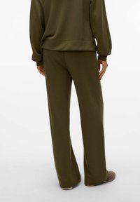 Olivgröna, vida sweatpants med en mjuk textur. Har en elastisk midja, avslappnad passform och hel längd.