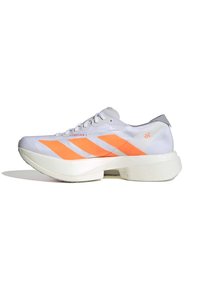 Zapatilla deportiva blanca con rayas diagonales naranjas, parte superior de tela ligera, suela texturizada y un acento gris en el talón. Talla indicada como 39.