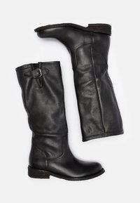 Black leather knee-high boots with a slightly pointed toe, low block heel, and a decorative strap with a buckle at the top.