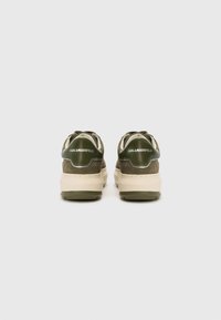 Green suede sneakers with a beige sole, featuring a padded collar, laces, and "KARL LAGERFELD" branding on the back.