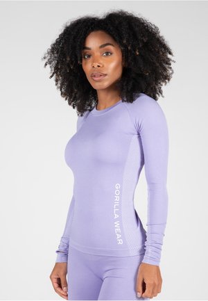 Maglietta sportiva a maniche lunghe di colore viola chiaro con pannelli laterali testurizzati e la scritta 'GORILLA WEAR' stampata in bianco sul lato. Design liscio e aderente.