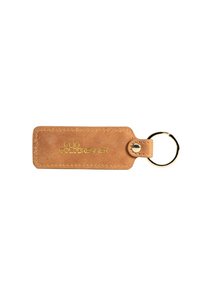 Porte-clés en cuir marron avec une étiquette rectangulaire, décorée de texte en relief doré et d'un attachement en métal. Texture lisse avec des bords arrondis.