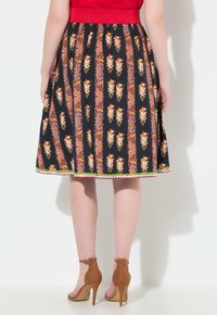 Schwarzer Rock mit floralem und Paisley-Muster in Orange, Pink und Weiß, mit einem roten Bund und einem dekorativen Saum.