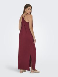 Bordeaux maxi jurk met een ontspannen pasvorm, racerback ontwerp, zijsplit en lichtgewicht stof. Draag met beige instappers.