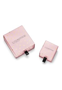 Rozā iepakojuma kastītes, viena liela ar zelta svītrām un ar vilkšanas cilpu, un viena mazā saderīga kaste, abas ar "Glanzstücke München" logotipu.