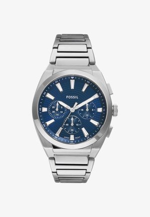 Montre-bracelet Fossil en acier inoxydable avec cadran bleu, trois sous-cadrans, index argentés et fonction date, affichant 10:10:38.