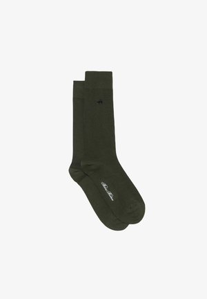Chaussettes en coton vert foncé avec bord-côte côtelé, présentant un petit emblème noir et un texte de marque blanc près des orteils. Texture lisse sur toute la surface.