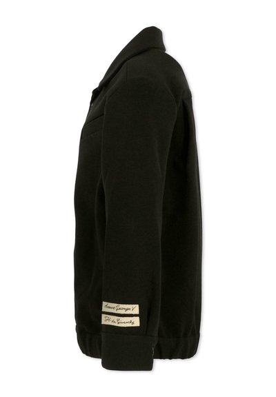 Czarna kurtka wykonana z bawełny, z kołnierzem, boczną kieszenią oraz dwoma materiałowymi etykietami na rękawie z kontrastującym jasnobrązowym tekstem.