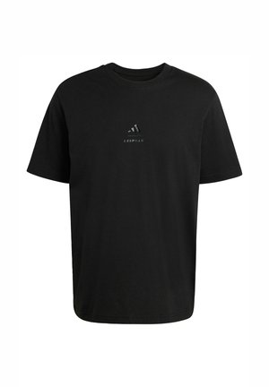 Musta, lyhythihainen pyöreäkauluksinen T-paita, jossa pieni Adidas-logo ja "LES MILLS" -teksti rinnan keskellä.