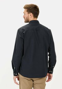 Marineblauwe langemouwen shirt met een button-down kraag, voorzien van een rugpand en knopen op de manchetten, gemaakt van gestructureerde stof.