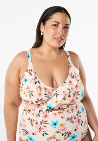 Blommig bikiniöverdel i ljus persikofärg, med volangdesign, blåa och rosa blommönster samt justerbara axelband för komfort.