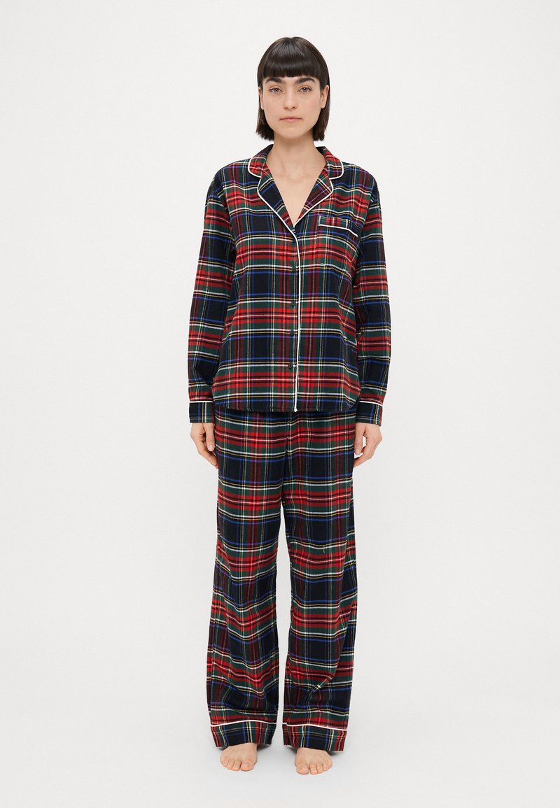 Røde og blå ternede pyjamaser med en knap-åben top og matchende bukser, med hvid piping og en brystlomme. 100% bomuldsstof, afslappet pasform.