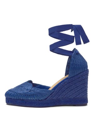 Alpargata cuña azul tejida con lazo para atar en el tobillo y detalle de puntera redonda, con entresuela trenzada texturizada y talón cerrado.