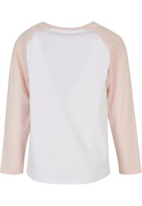 Ilga rankovė T-shirt su balta liemene ir šviesiai rožinėmis raglano rankovėmis. Pagaminta iš švelnios medžiagos, turi apvalų iškirpimą ir tiesų kraštą.