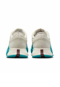 Zapatillas deportivas en blanco y aqua con un upper texturizado, cuello acolchado y acento en el talón marrón. Presentan un diseño ligero y suela de goma.
