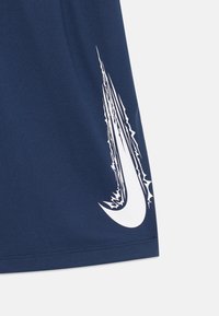 Námořnické atletické šortky s velkým bílým logem Nike swoosh a ostrými, zubatými akcentmi. Vyrobené z prodyšného materiálu s texturovaným povrchom.