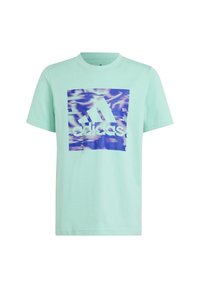 Mátově zelené bavlněné tričko s krátk�ým rukávem, na kterém se nachází čtvercové grafické logo Adidas v modré a fialové barvě s vlnitým vzorem za logem.