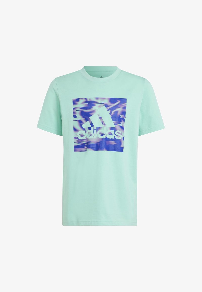 Camiseta de algodón verde menta con un logo gráfico de Adidas en forma de cuadrado en azul y púrpura, con un patrón ondulado detrás del logo. Manga corta.