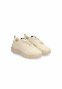 Scarpe da ginnastica beige con una finitura lucida, modelli testurizzati sulla tomaia e una suola spessa e gonfiabile con piccole sporgenze.