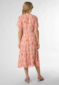 Sukienka printowana z falbaniastymi rękawami, w pastelowym, abstrakcyjnym wzorze w kolorach różowym, pomarańczowym i kremowym. Midi długość z dopasowanym wcięciem w talii.