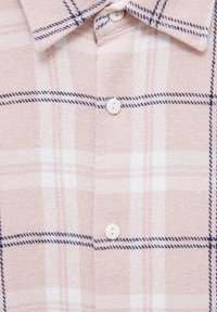 Camisa de franela rosa claro con un patrón de cuadros en líneas blancas y azules marino, cuello estándar y botones blancos. Textura suave.