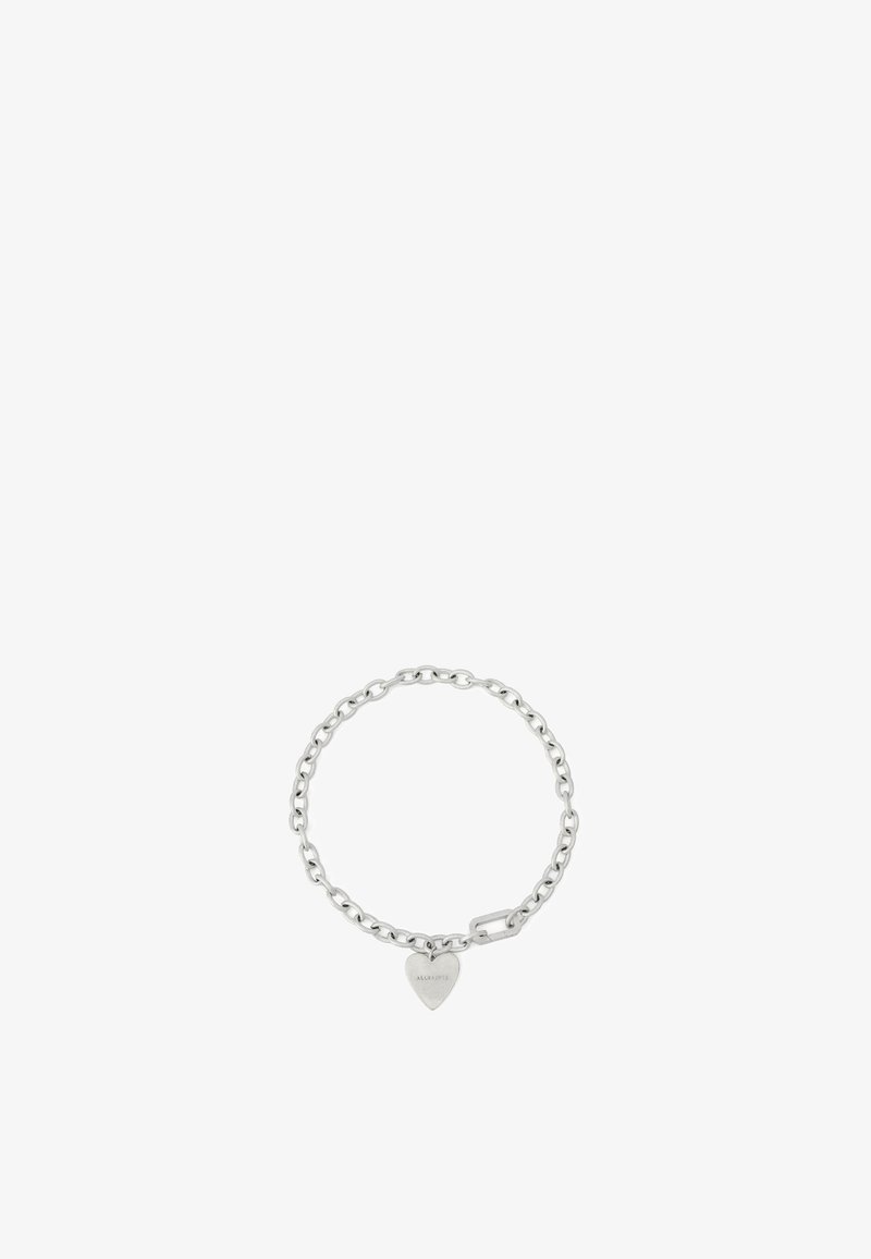 Bracelet en chaîne de métal argenté avec des maillons arrondis et un pendentif en forme de cœur gravé. Le design est minimaliste et se ferme par un fermoir.