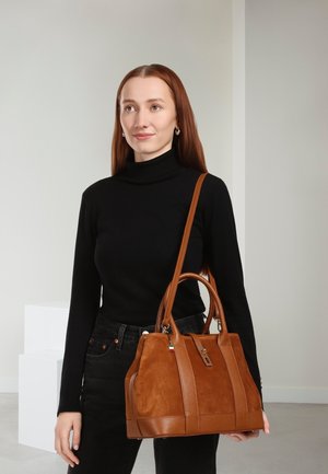 Sac à main en cuir et daim marron avec deux anses, fermeture éclair et bandoulière amovible. Doté d'accents texturés et d'une étiquette.
