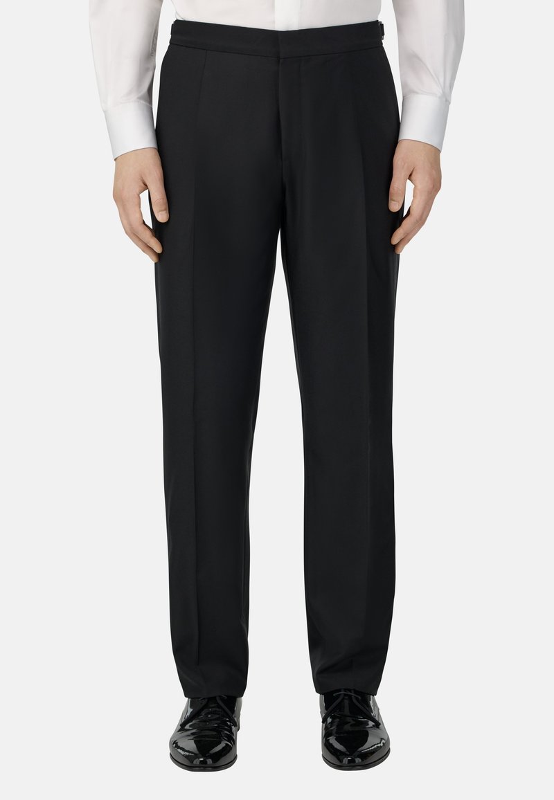 Černé formální kalhoty s elegantním designem, plochým předním dílem a rovnými nohavicemi, vyrobené z hladkého materiálu. V kombinaci s lesklými černými botami.