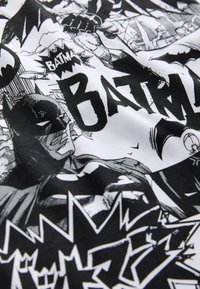 Bomullstyg med en svart och vit serietidningsdesign som har framträdande Batman-bilder, djärv text och olika grafiska element.