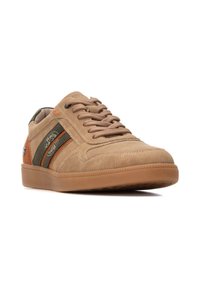Zapatillas de ante beige con cordones a tono, rayas olivas y naranjas, y suela de goma texturizada. Presenta el logo de la marca en un lado.
