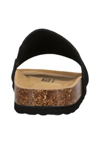 Sandale noire à lanière large, avec une semelle intermédiaire en liège et une semelle extérieure en caoutchouc texturé. L'intérieur présente une semelle intérieure douce de couleur beige.