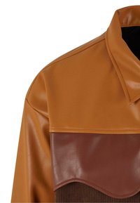 Braune Kunstlederjacke mit einer glatten, glänzenden Textur, einem umgeschlagenen Kragen und einem kontrastierenden, dunkler braunen unteren Teil mit gewelltem Saum.