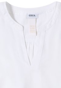 Blouse blanche avec un col rond présentant une fente en forme de V et un petit détail plissé sous le col, étiquetée "CECIL seaside".