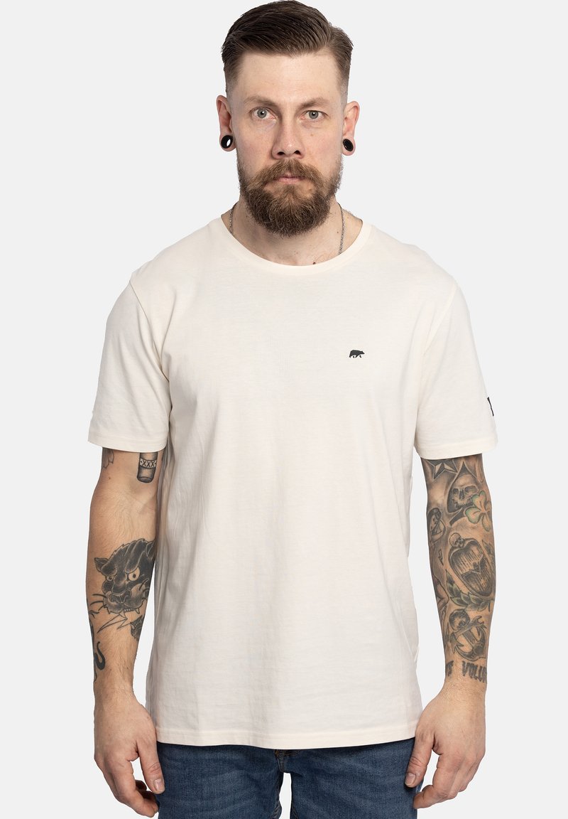 T-shirt beige chiaro in cotone, con scollatura rotonda, maniche corte e un piccolo logo di un orso nero sul petto.