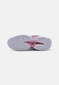 Suola di scarpa atletica bianca con una superficie testurizzata, caratterizzata da accenti rosa e grigi e da un motivo geometrico per migliorare la trazione.