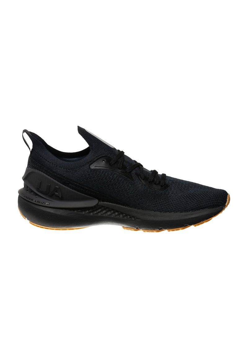 Scarpa sportiva nera con tomaia in tessuto a maglia, finitura testurizzata e suola in gomma. Presenta una linguetta e un accento del marchio sul lato.