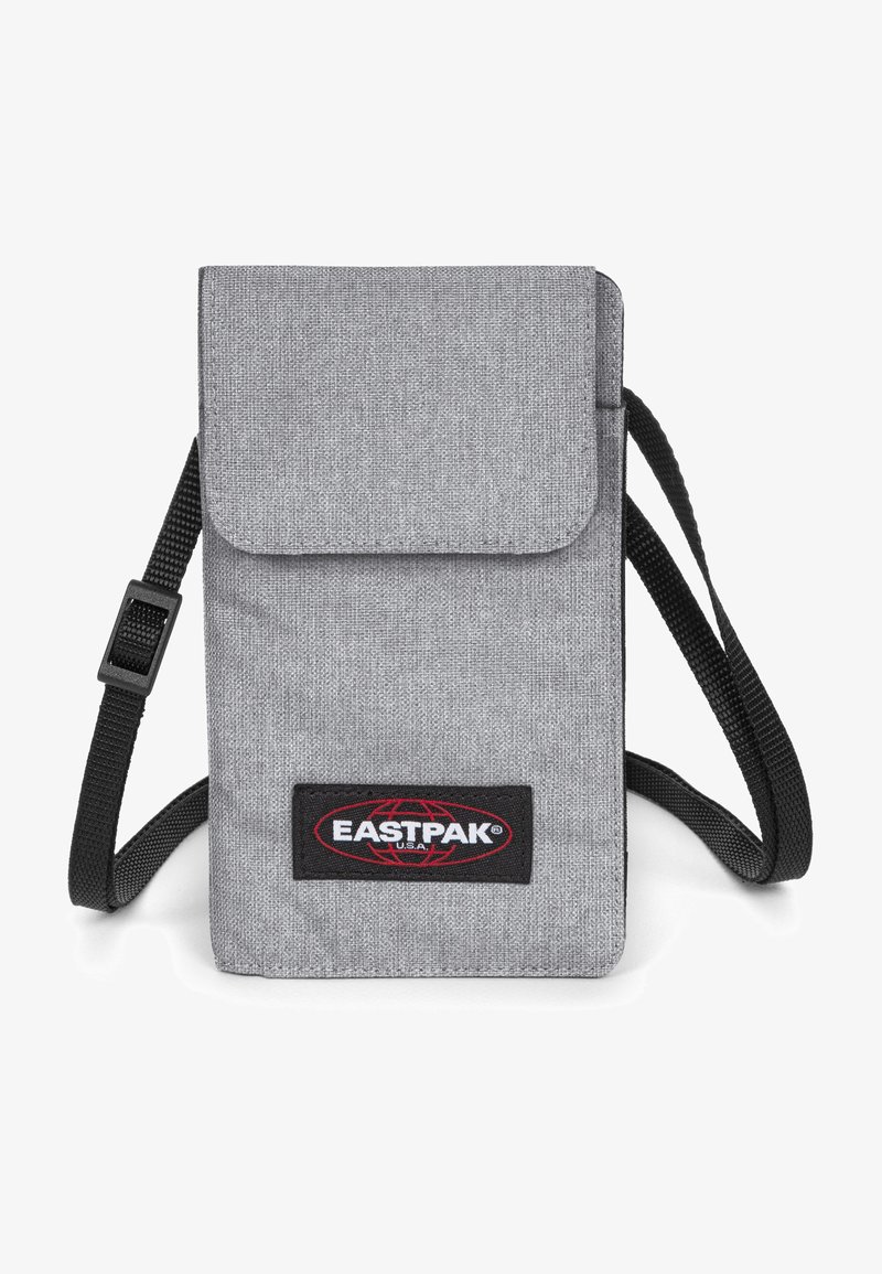 Borsa a tracolla in tessuto grigia con chiusura a patta, tracolla nera e patch con logo Eastpak sul davanti. Design compatto per la portabilità.