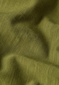 Tessuto strutturato verde oliva, caratterizzato da un motivo intrecciato con sottili costine. Il materiale sembra morbido e leggermente elastico.