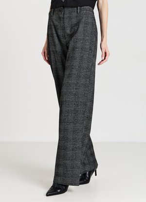 Graue, karierte, weit geschnittene Hosen mit hoher Taille und seitlichen Taschen, gefertigt aus strukturiertem Stoff, kombiniert mit schwarzen Schuhen mit Absatz.