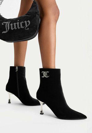 Stivaletti in camoscio nero con tacchi kitten argento e dettagli monogramma, abbinati a una borsa a tracolla nera con scritte in strass "Juicy".