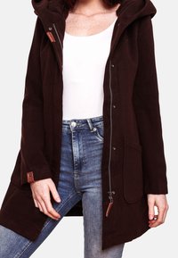 Cappotto in pile marrone con cappuccio, chiusura con zip e dettagli con bottoni. Presenta tasche laterali e una vestibilità casual e rilassata.