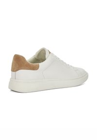 White leather sneaker with a light brown suede heel cap, rounded toe, and flat sole. Stitched detailing on the upper. Laced closure.