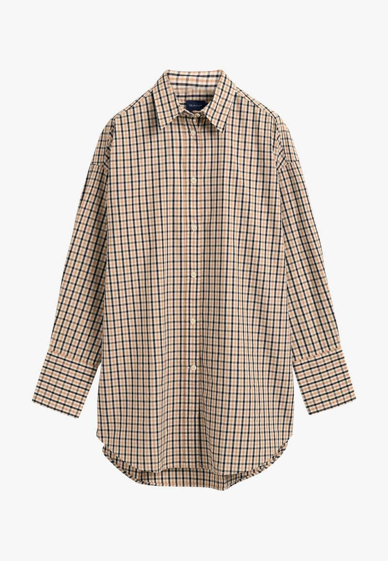 Chemise à manches longues boutonnée à motif à carreaux beige, noir et blanc avec un col pointu.
