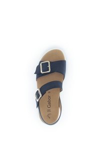Marineblauwe sandaal met twee brede banden, zilveren gesp en een gevoerde beige binnenzool. Ontworpen voor comfort met een platte zool.