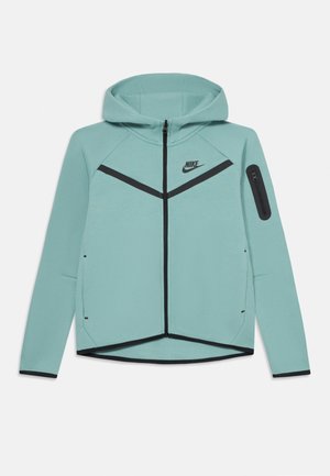 Felpa zip-up Nike di colore azzurro chiaro con accenti neri, cappuccio, maniche lunghe e una piccola tasca con zip sul braccio sinistro.