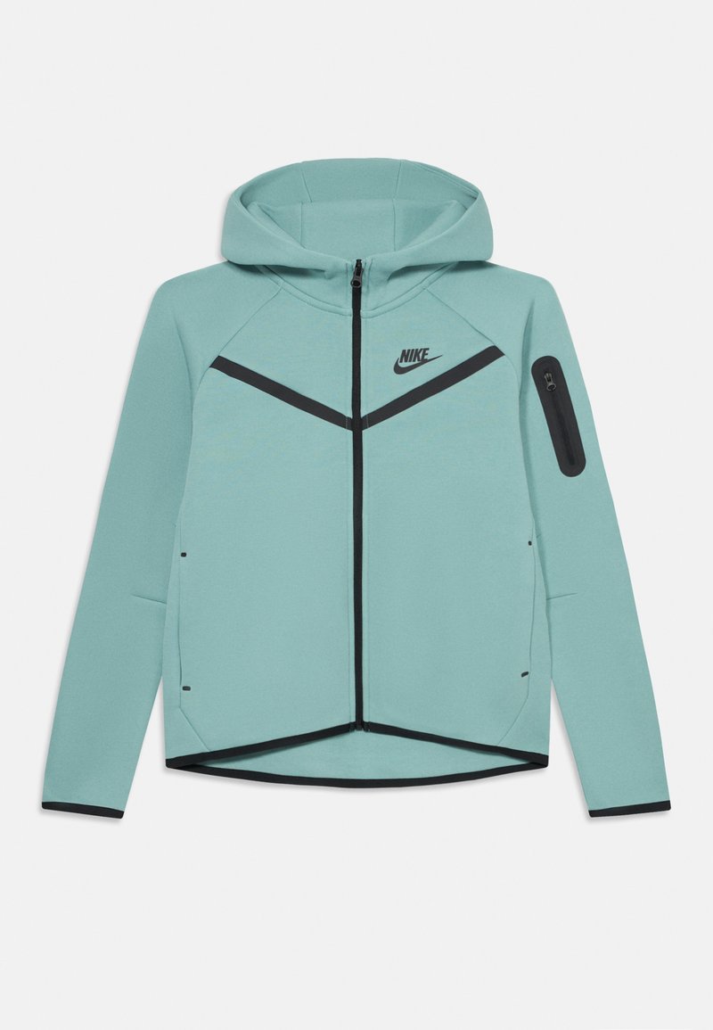 Ανοιχτό μπλε ζακέτα Nike με φερμουάρ, με μαύρες λεπτομέρειες, κουκούλα, μακριά μανίκια και μία μικρή τσέπη με φερμουάρ στο αριστερό μανίκι.