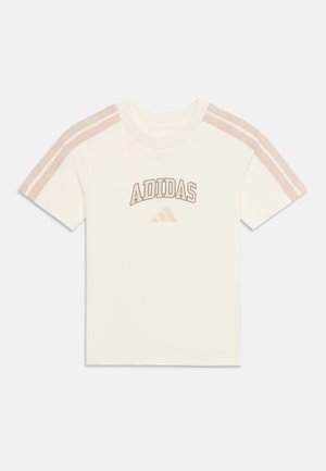 T-shirt blanc manches courtes Adidas avec des rayures beige sur les épaules et le texte et le logo "ADIDAS" en beige sur la poitrine.