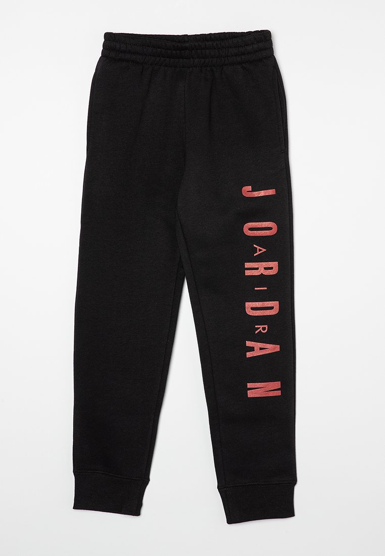 Pantaloni jogger neri con elastico in vita, gambe affusolate e un logo rosso verticale stampato lungo il lato sinistro. Tessuto morbido con una superficie liscia.