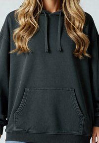 Sweatshirt à capuche en charbon fabriqué en tissu doux, avec une poche kangourou et des poignets et un ourlet côtelés. Coupe décontractée avec des épaules tombantes.