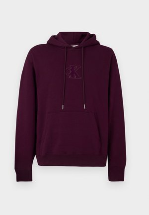 Burgunderfarbener Hoodie mit geräumiger Fronttasche, Kapuze mit Kordelzug und gesticktem Logo in passender Farbe auf der Brust. Weiches, Baumwollmischgewebe.